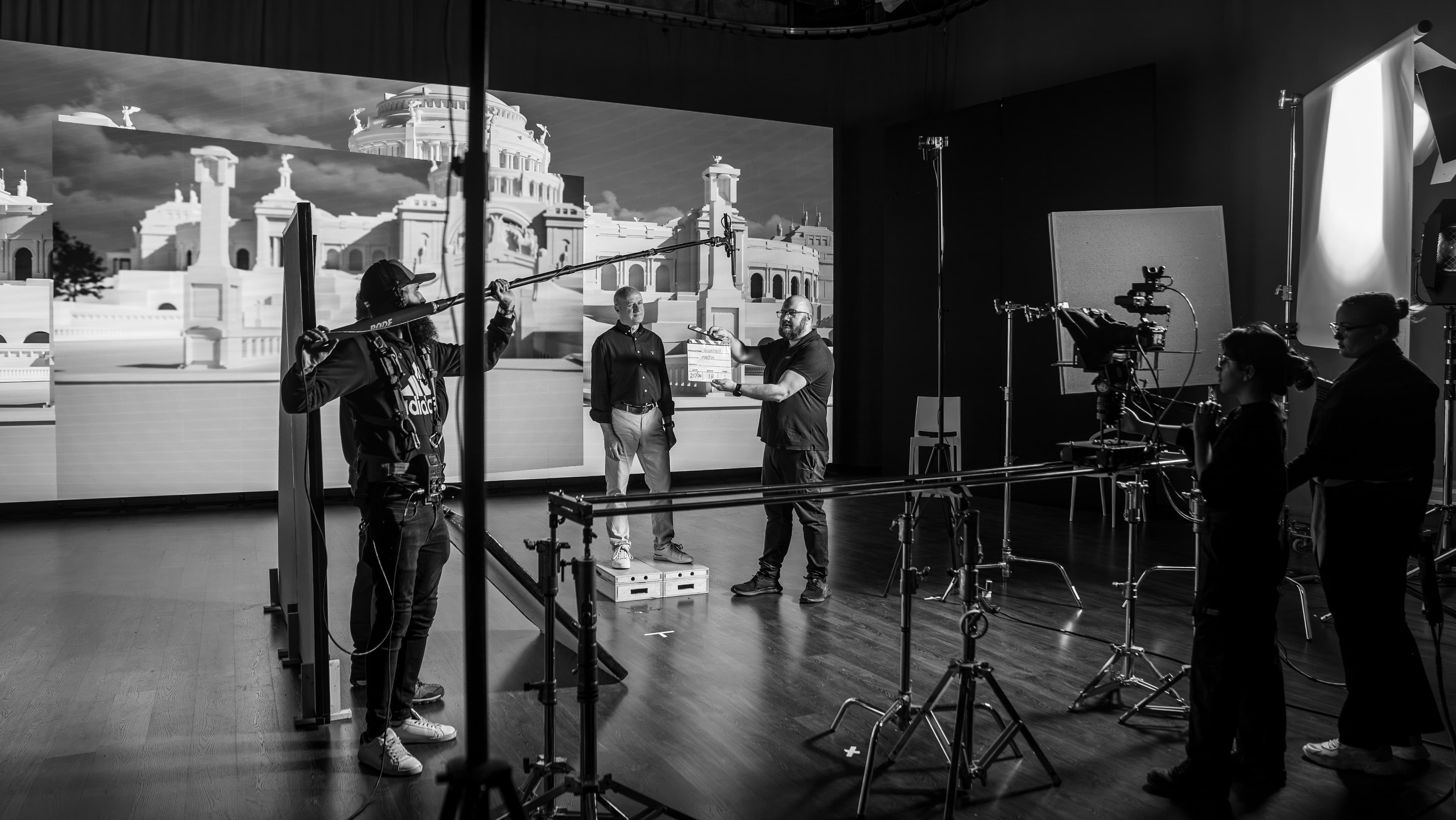 On set for a virtual-production shoot, clapperboard in hand